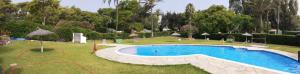 a swimming pool in the middle of a yard with trees at Sea shells at Bahia Dorada in Estepona