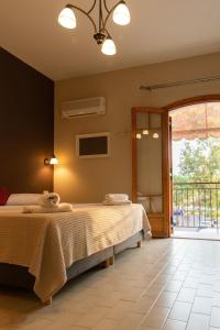 a bedroom with two beds and a balcony at Sisiotisa in Argostoli