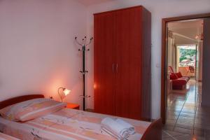a bedroom with a bed and a red cabinet at Apartmenthaus Kosirina-Tisno in Tisno