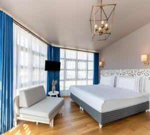 een slaapkamer met een wit bed en een stoel bij Petros Hotel in Istanbul
