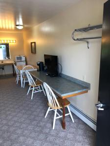 
a kitchen area with a table and chairs at Village Inn Motel in Chatham
