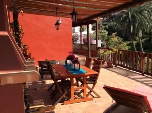 een houten tafel en stoelen op een patio bij Casa Rural La Pitanga in Hermigua