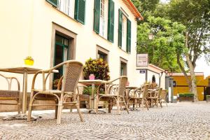 a group of chairs and tables in front of a building at Amparo in Machico