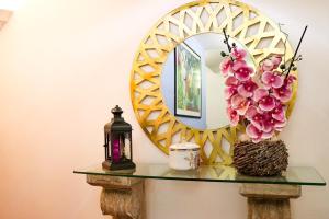 un espejo y un jarrón con flores en una mesa en Amparo, en Machico