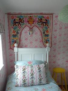 a bedroom with a bed with a pink wall at Glory Days in Cromer