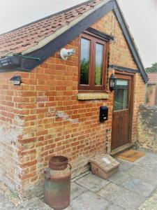 una casa de ladrillo con una ventana y una puerta en Oak Cottage en Taunton