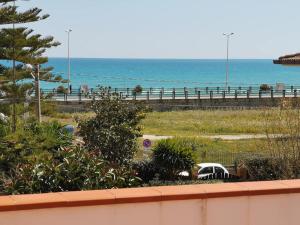 a view of the beach and the ocean with a car at Lido di Noto Villa Cocus Apartment Vista Mare in Noto Marina