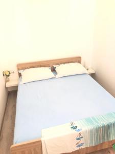 ein Bett mit zwei Kissen auf einem Zimmer in der Unterkunft Little house Ljubica in Kampor