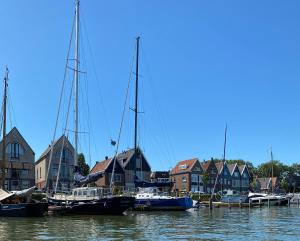 um grupo de barcos ancorados num porto com casas em Who's Anton for you or two, Monnickendam near Amsterdam em Monnickendam