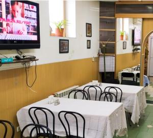 a restaurant with tables and chairs and a tv on the wall at КЛУБ B55 in Dnipro
