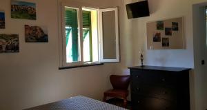 1 dormitorio con vestidor, ventana y silla en CASA ELA en Levanto