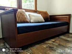 drewniana ławka z poduszką w pokoju w obiekcie Holiday home Haustor with Skadar lake view w mieście Podgorica