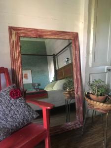 einen Spiegel vor einem Schlafzimmer mit einem Bett in der Unterkunft Casa típica de Tigre in Tigre