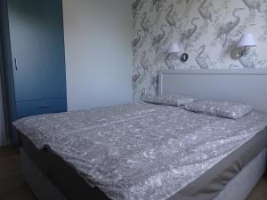 1 dormitorio con 1 cama con 2 almohadas en VIP apartament w parku nad Zatoką, en Puck