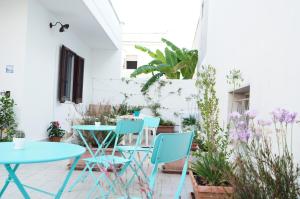 un patio con mesas azules, sillas y plantas en Il Rifugio del Navigante en Otranto