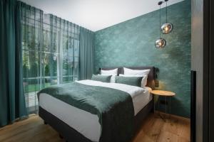 a bedroom with a bed and a green wall at Luxury Apartments "R6 Tegernsee" in Bad Wiessee