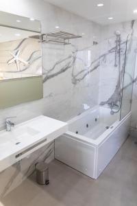 a white bathroom with a tub and a sink at Lagos Atlantic Hotel in Lagos
