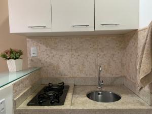 a kitchen with a sink and a stove at Espaço Praia - Studio 109 in Angra dos Reis