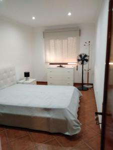 um quarto com uma cama, uma cómoda e uma janela em Maré Beach em Monte Gordo