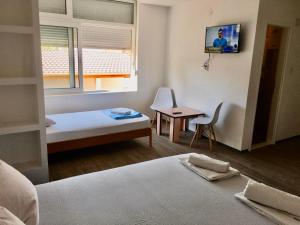 a bedroom with a bed and a table and a window at Rooms M2 in Trebinje