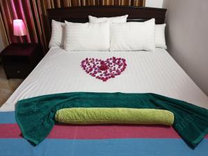 Una cama con dos corazones encima. en Nima villa en Tangalle