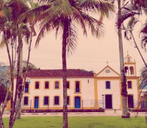 a building with palm trees in front of it at Espaço Praia - Studio 109 in Angra dos Reis +11 photos