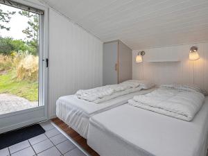 Fjand Gårdeにある6 person holiday home in Ulfborgの窓付きの部屋 ベッド3台