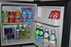 um frigorífico aberto cheio de refrigerantes e bebidas em The Alima Suites em Accra