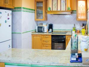 a kitchen with a refrigerator and a counter top at Belvilla by OYO Preciosa casa en Sevilla in Seville