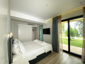 a bedroom with a bed and a large window at EOS Luxury Suites in Kriopigi +51 photos