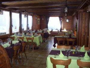 un restaurante con mesas verdes, sillas y ventanas en Hôtel du Gd-St-Bernard, en Liddes