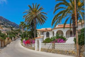a house on a street with palm trees and flowers at Maryvilla Inspiración y Vacaciones - Villa Mascarat in Calpe