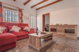 Una sala de estar con un sofá rojo y una mesa. en Casa Yamile, en Tarajalejo