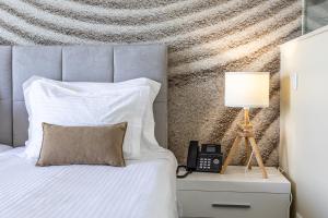 a bedroom with a bed with a lamp and a phone at Lagos Atlantic Hotel in Lagos