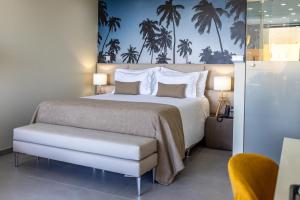 a bedroom with a bed and palm trees on the wall at Lagos Atlantic Hotel in Lagos