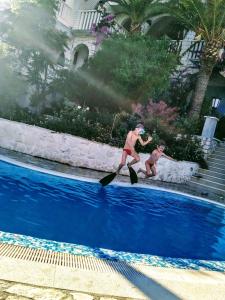 dos hombres en esquís acuáticos en una piscina en Villa Clematis, en Trogir