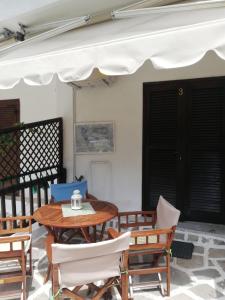 Un patio con una mesa y sillas y una sombrilla. en Xellena apartment, en Kallithea Halkidikis