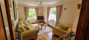 a living room with two chairs and a television at The Haven in Keswick