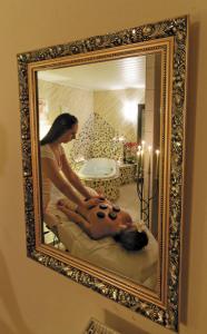una mujer recibiendo un masaje de espalda en un espejo en Panorama-Hotel am See en Neunburg vorm Wald