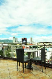 einen Tisch und Stühle auf einem Balkon mit Stadtblick in der Unterkunft GV Tower Hotel in Cebu City
