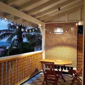 a patio with a wooden table and a window at Studio Frangipani dans Villa Fleurs des Iles in Le Vauclin