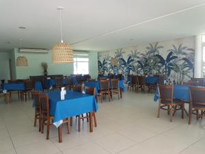 uma sala de jantar com mesas e cadeiras azuis em CARNEIROS BEACH RESORT- Flat de 2 quartos - condomínio à beira mar da Praia de Carneiros em Praia dos Carneiros