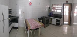 a kitchen with a table in the middle of it at Apto Ocian in Praia Grande