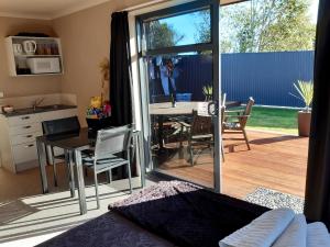 a bedroom with a kitchen and a dining room with a table at Modern BNB unit with Wifi and Breakfast in Greymouth