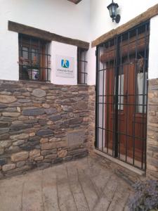 einen Eingang zu einem Gebäude mit einer Steinmauer in der Unterkunft Casa Maldonado in Yátor