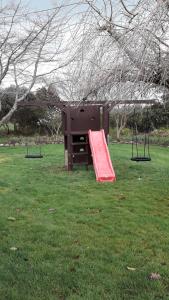 a playground with a red slide in a park at Kaimai Sunset Bed & Breakfast in Matamata