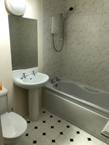 a bathroom with a sink and a tub and a toilet at Spacious home by the sea in Scalloway. in Scalloway