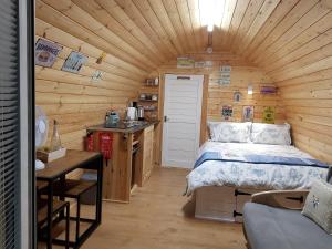 a bedroom with a bed in a wooden cabin at Lanterns Shepherds Huts & Glamping in Happisburgh