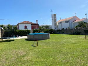 a large yard with a trampoline in the grass at Beach House with Swimming Pool in Vila do Conde