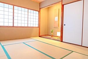 an empty room with a door and windows at Nishihan in Kyoto